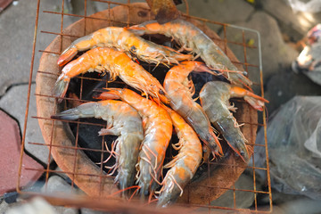 Raw shrimps on flaming grill