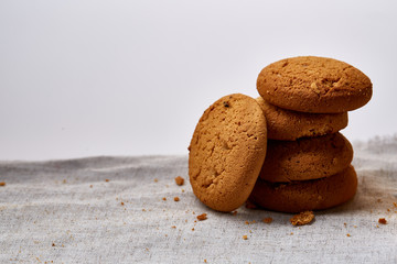 Pile of oat cookies on homespun napkin, close-up, selective focus.