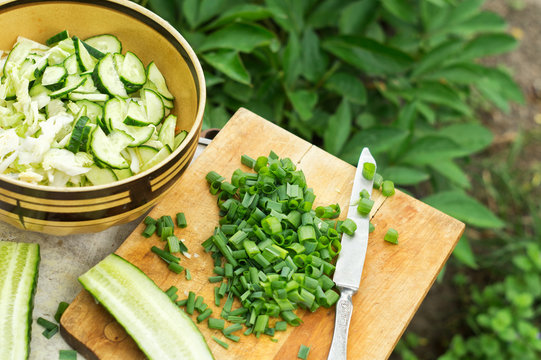 Sliced green onions and salad with cucumbers and cabbage