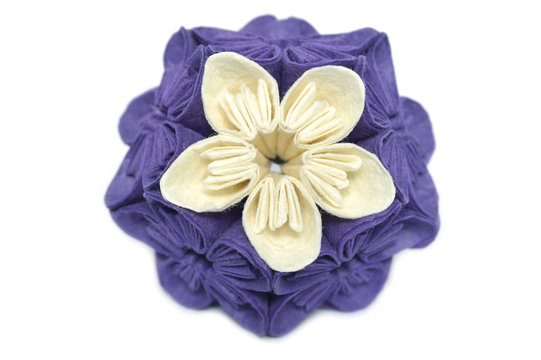 Purple and white origami kusudama flower on white background