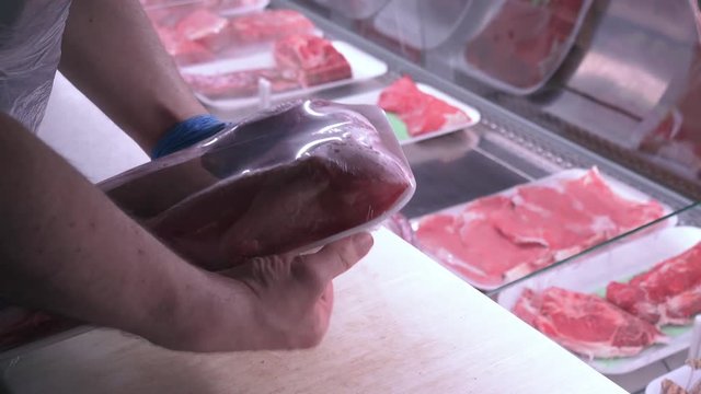 Food industry, packaging of beef meat in a butchery, zooming out