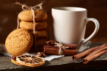 Traditional Christmas tea concept with a cup of hot tea, cookies and decorations on a wooden table, selective focus