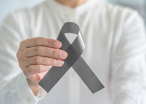 Brain cancer awareness with grey ribbon on helping hand, symbolic bow color for Brain tumor, Allergies, Alpha-1 Antitrypsin Deficiency, Aphasia, Asthma, Borderline Personality Disorder