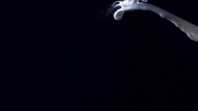 The jets of the white liquid collide and spill.
