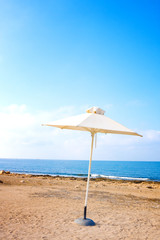 Obraz na płótnie Canvas Alone sunumbrella at mediterranean beach in the morning, Paphos, Cyprus
