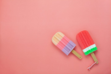 Table top view aerial image of food for summer holiday background concept.Flat lay arrangement variety ice cream pop stick on modern rustic pink paper wallpaper at office desk.Pastel tone design.