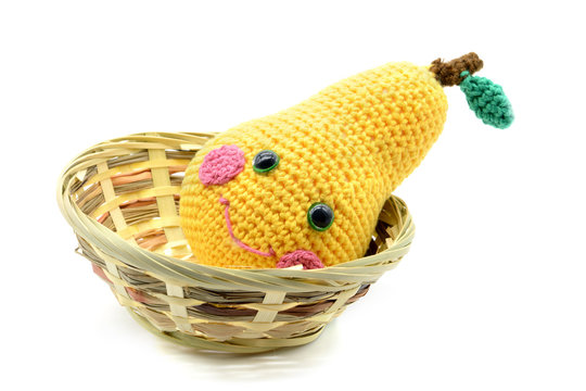 crochet yellow pear in a basket at white isolated background
