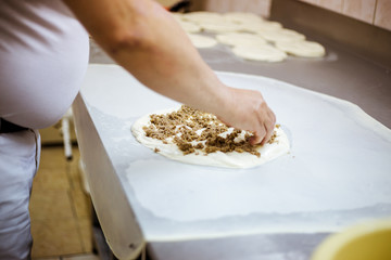 Man baker working in bakery shop