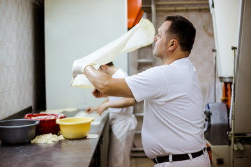 Man baker working in bakery shop