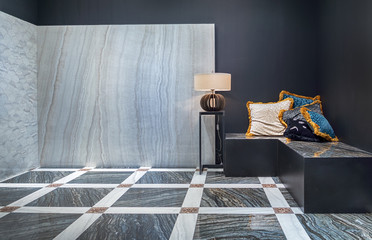 A modern interior of the living room in the black and white color with natural marble on the floor and on the wall