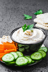 Artichoke white bean dip on dark concrete background. Selective focus, space for text. 