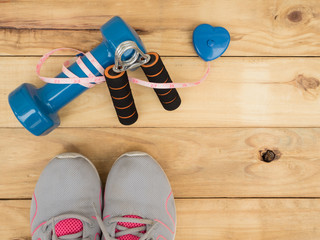 blue dumbbell and measure and shoes sport on wooden background with copy space