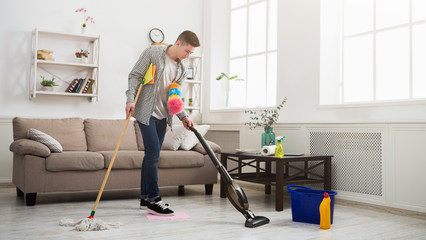 Young man cleaning house with lots of tools