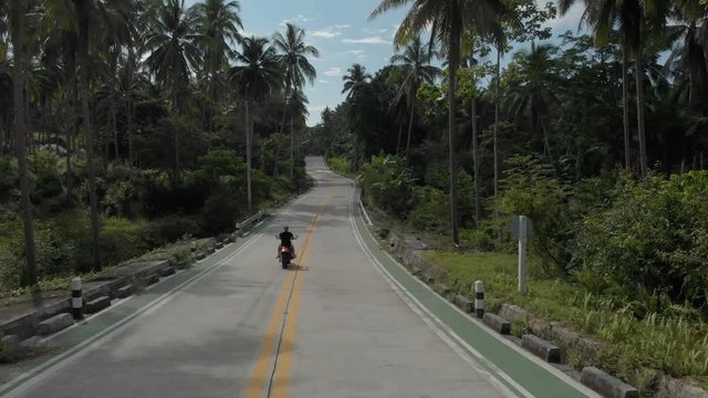 2 flat aerial shots in cinelike-D. Biker riding motorcycle by the road