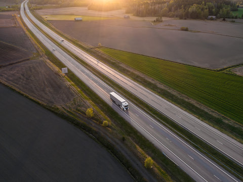 Aerial View Of Highway With Cargo Truck Driving By At Spring Sunset