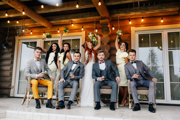 The bride and groom, along with their guests, settled on the porch of the house