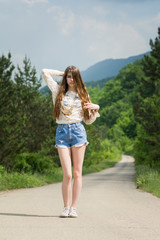 Gorgeous young female model outdoors on sunny summer day wearing boho outfit. No retouch, natural lighting.