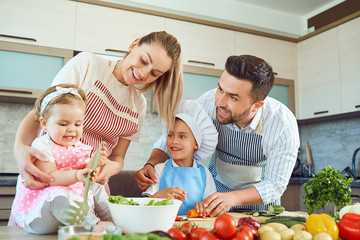 A happy family is preparing vegetables in the kitchen.
