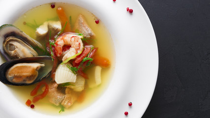 Healthy delicatessen seafood soup of white fish, shrimps and mussels