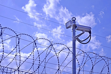 Obraz premium Fence, barbed wire and video camera.