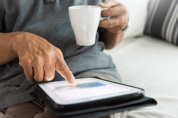 Senior male hands using a digital tablet.