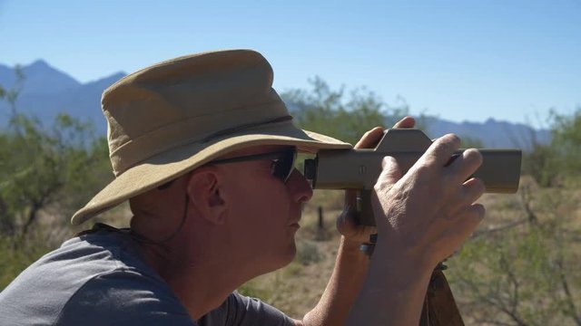 A land surveyor sighting property lines