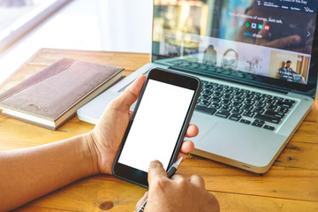 Businessman hands holding and using mobile smartphone in office.  and computer screen.Close up