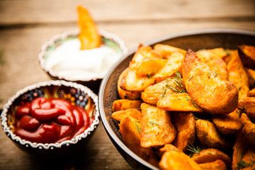 Baked potato fries on wooden table