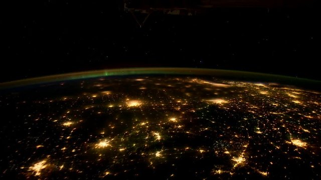 Wide timelapse, city lights from Earth illuminate into space