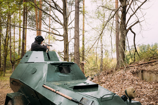 Re-enactor Dressed As Russian Soviet Crew Member Soldier Of World War II Sitting In Armoured Soviet Scout Car BA-64