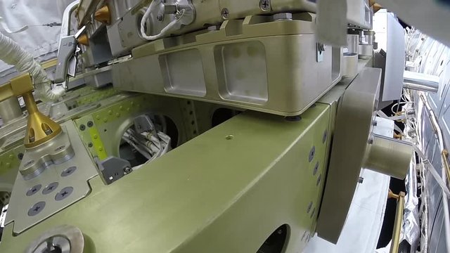 POV close up, astronaut uses tool on outside of ISS