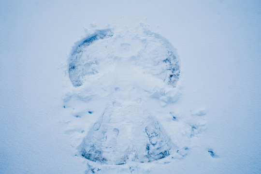 Snow angel in the snow, drawing on the ground in the cold winter