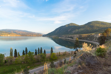 View of Okanagan Lake from above Sun Oka Provincial Park and highway 97 with city of Penticton in distance at sunset
