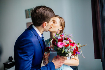 First look of happy wedding couple in the morning. Bride give groom buttonhole. Emotional wedding moment for young people.