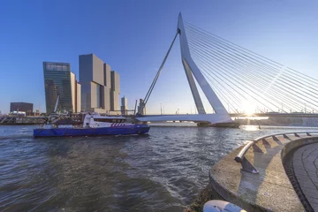 Photo sur Plexiglas Pont Érasme ROTTERDAM, 24 March 2016 - Police cruse control vessel navigating on the Rotterdam river and under the Erasmus bridge at the sunset moment
