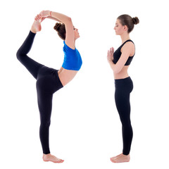 side view of two young slim women doing yoga isolated on white