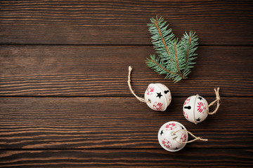 Christmas background with fir branches, toys and bells on wooden old background table. Selective focus. Top view with copy space.