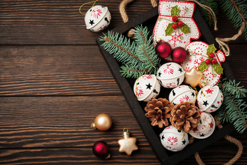 Christmas background with fir branches, toys and bells on wooden old background table. Selective focus. Top view with copy space.