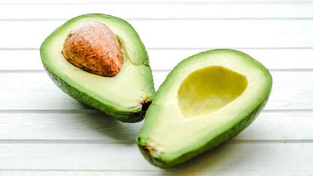 Halves of avocado on a white background close-up
