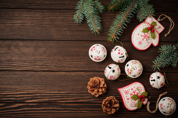 Christmas background with fir branches, toys and bells on wooden old background table. Selective focus. Top view with copy space.