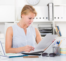 portrait of  business woman  writing and working with laptop in office