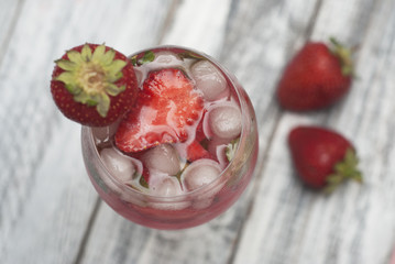 Fototapeta na wymiar Homemade Delicious Red Sangria with Strawberry Ice Summer Drink Rustic Gray Wooden Background