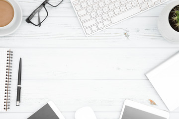 White office desk table with laptop, cup of coffee and supplies. Top view with copy space.