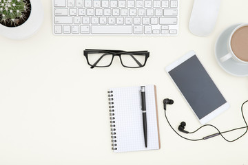 White office desk table with laptop, cup of coffee and supplies. Top view with copy space.