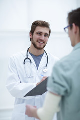 podiatrist writing a prescription to her patient.