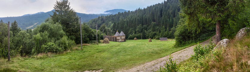 Rural landscape, panorama, banner - view on of the wooden historical reconstruction in vicinity of the Tustan medieval fortress, in the Ukrainian Carpathians