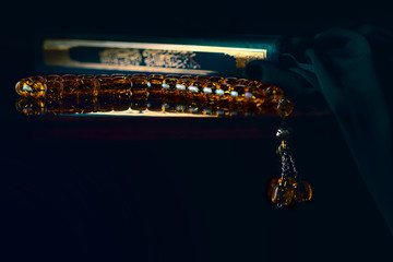 Holy islamic book Koran on the draped table with a rosary. Ramadan Kareem beautiful poster, banner,...