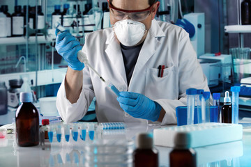 scientist pipetting tube test in the research laboratory / researcher holding pipette and tube for...