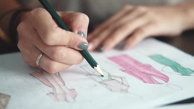 designer of clothes makes an outline of clothes with a felt-tip pen. female hands closeup