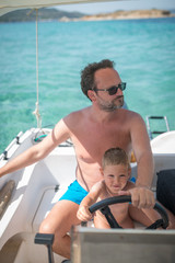 Caucasian man with son driving speed boat